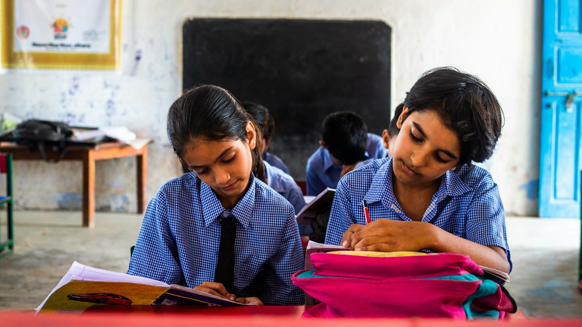 School girls in uniform writing in class