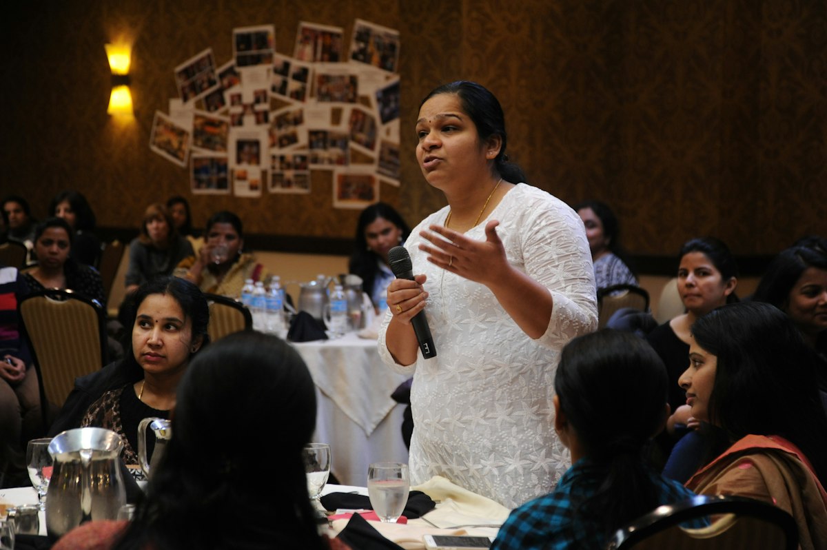 Student speaking with a microphone in front of a group